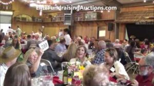 charity auction bidder raising bid paddle